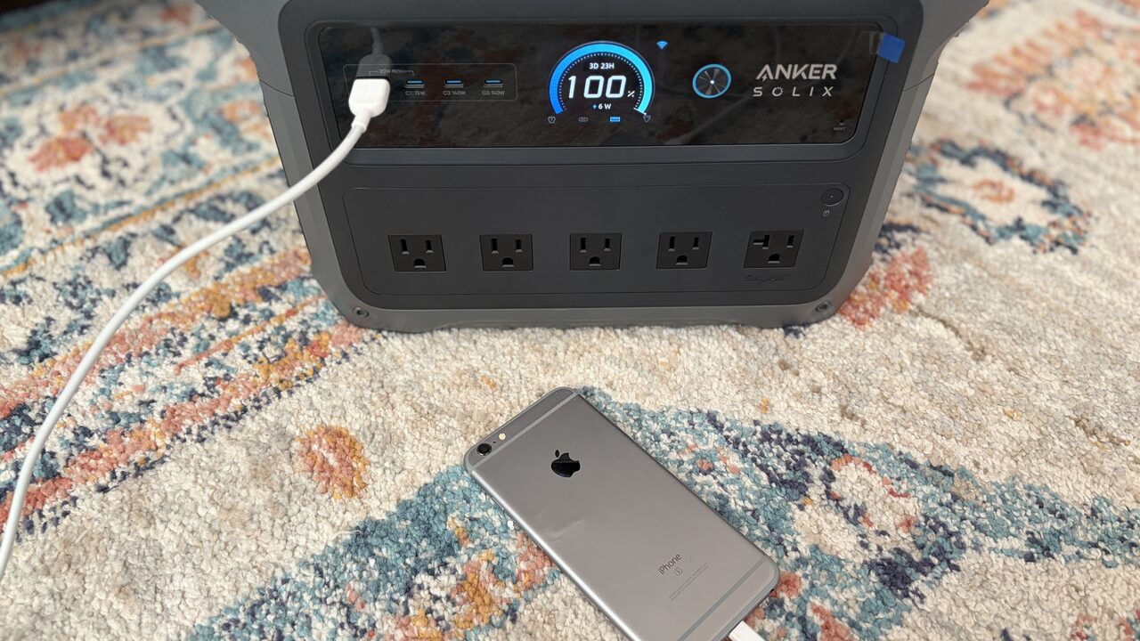 Anker SOLIX C1000 Gen2 Review A phone charging from the Anker SOLIX C1000 Gen2, display showing 100% charge, 3 days 23 hours remaining, and 6W draw